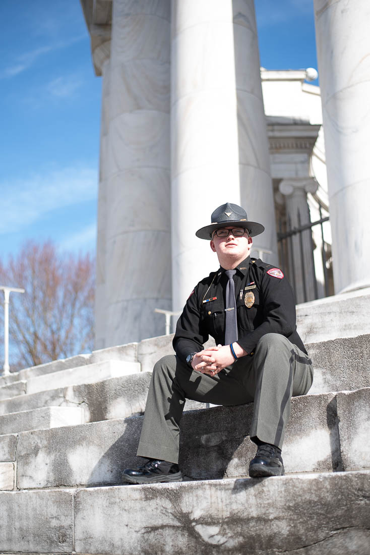 Young man sitting in cop uniform.